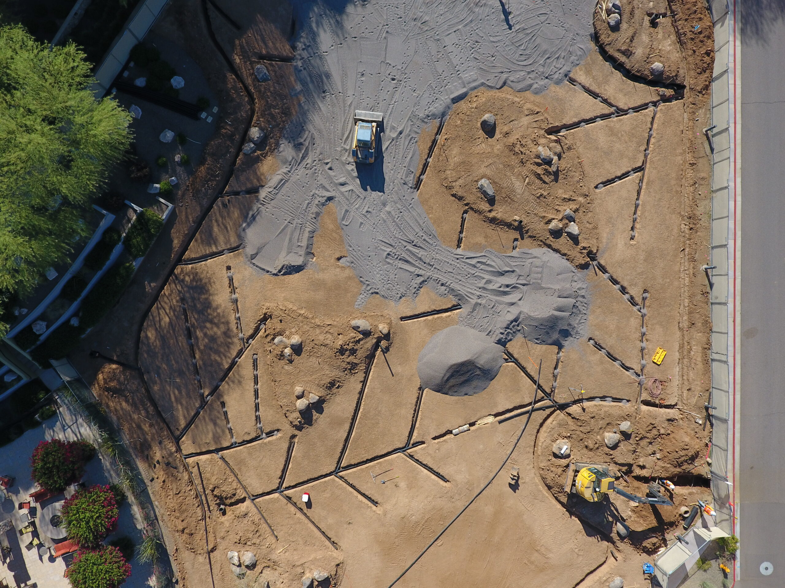 Aerial view of a golf course under construction with heavy equipment shaping fairways