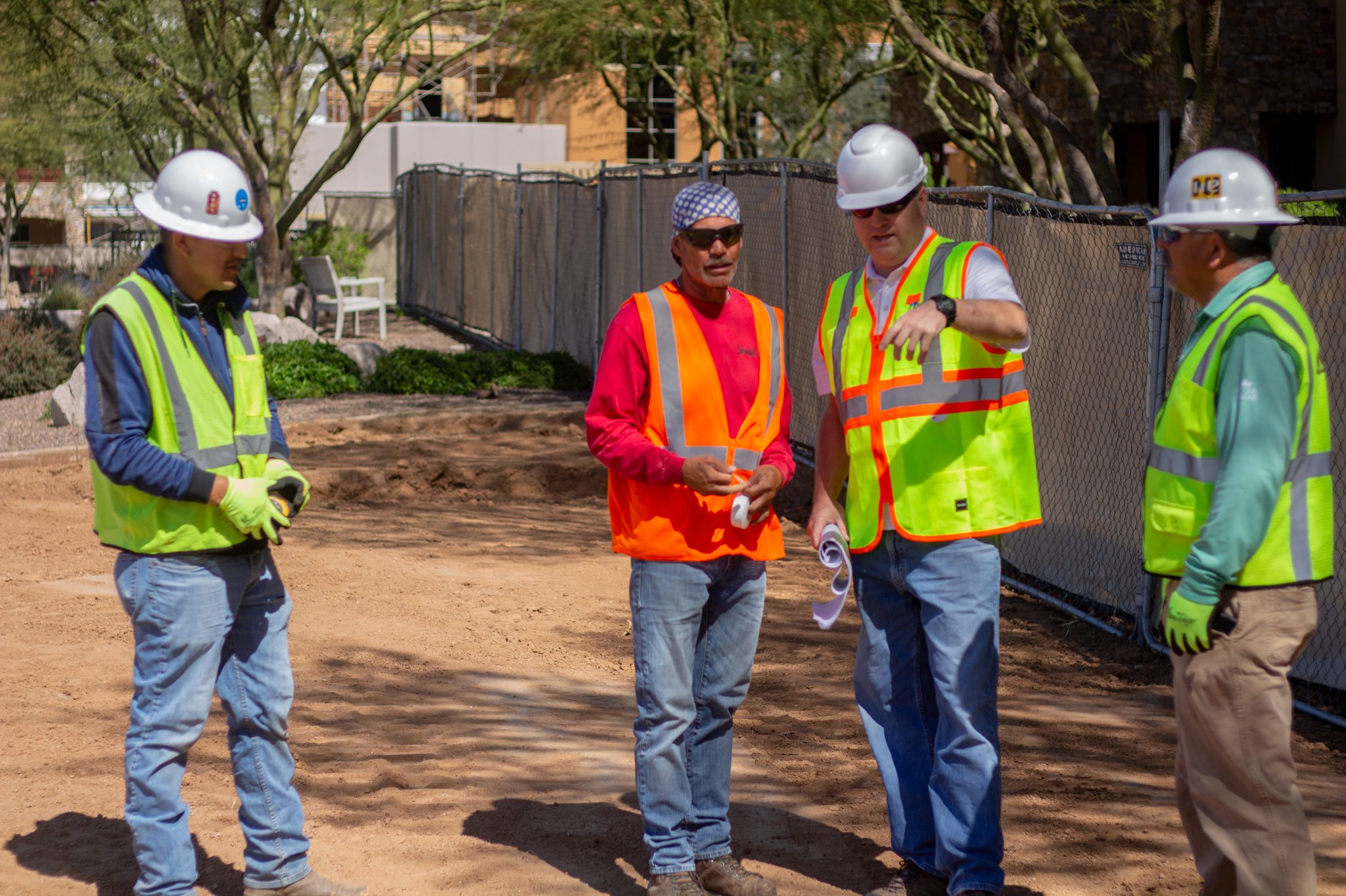 Team members reviewing golf course landscape construction details during an on-site planning discussion